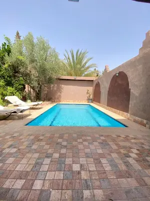 a swimming pool in a yard with a patio at Villa des Roses Privée in Marrakech