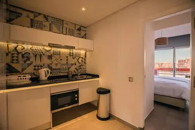 a kitchen with a stove top oven next to a bed at M Appart in Marrakech