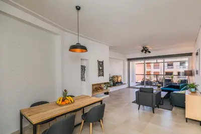 a dining room and living room with a table and chairs at M Appart in Marrakech