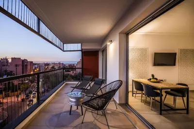 a balcony with a table and chairs and a view at M Appart in Marrakech