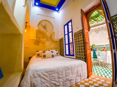 a bedroom with a bed in a room with a window at Dar Sarsar Artistic Music in Marrakech