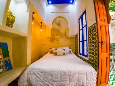 a bedroom with a bed and a window at Dar Sarsar Artistic Music in Marrakech