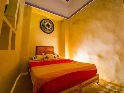 a bedroom with a bed with a clock on the wall at Dar Sarsar Artistic Music in Marrakech