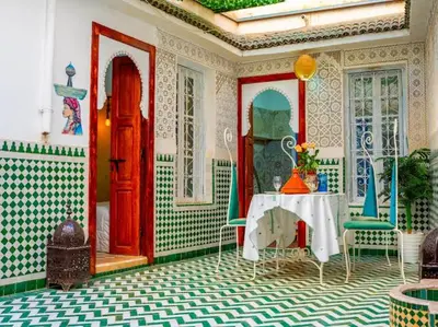 a room with a table and a red door at Dar Sarsar Artistic Music in Marrakech