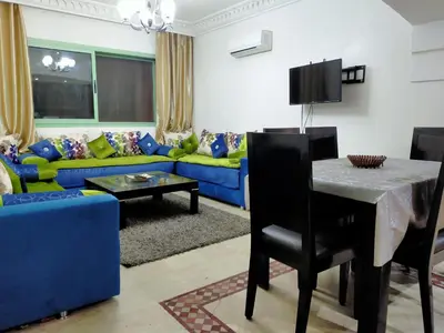 a living room with a blue couch and a table at Appartement Maria in Marrakech