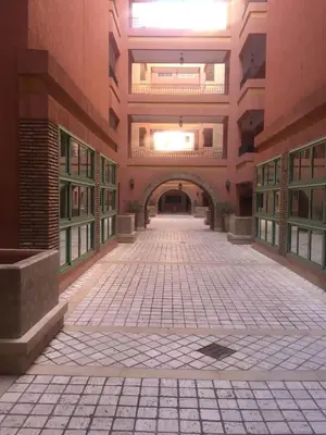 an empty hallway in a large building with a tile floor at Appartement Maria in Marrakech