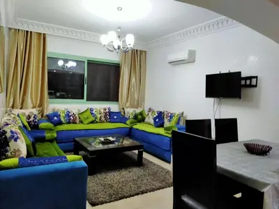 a living room with a blue couch and a table at Appartement Maria in Marrakech