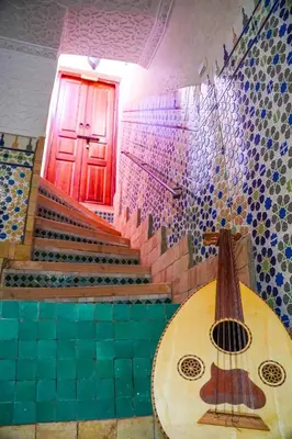a room with a table and stairs with a red door at Riad Sarsar Dar dmana in Marrakech