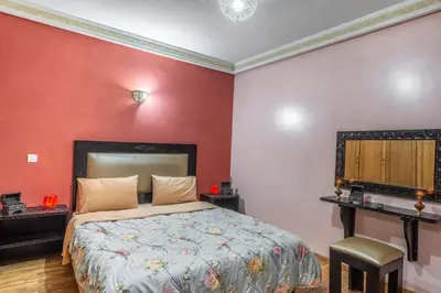 a bedroom with a bed with red walls and a desk at Majorelle family residence in Marrakech