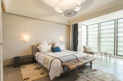 a bedroom with a large bed and a large window at Villa YENMOZ en exclusivité avec piscine privée dans la Palmeraie in Douar Caïd Layadi