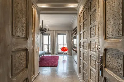 a hallway with wooden doors and a red rug at Villa YENMOZ en exclusivité avec piscine privée dans la Palmeraie in Douar Caïd Layadi