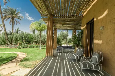 a deck with chairs and a couch on a house at Villa YENMOZ en exclusivité avec piscine privée dans la Palmeraie in Douar Caïd Layadi