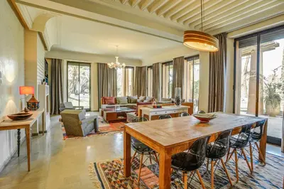 a large living room with a table and chairs at Villa YENMOZ en exclusivité avec piscine privée dans la Palmeraie in Douar Caïd Layadi