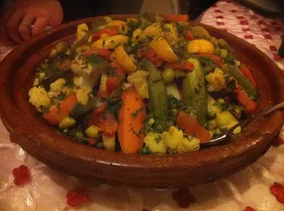 a bowl of vegetables with a spoon in it at Riad Elias & Spa in Marrakech