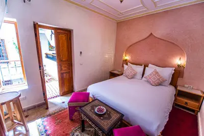 a bedroom with a large white bed and a table at Riad Zahri in Marrakech
