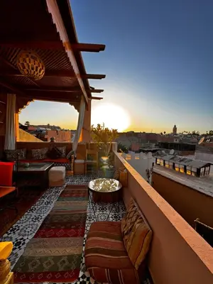 a balcony with couches and a table on a roof at Riad Zahri in Marrakech
