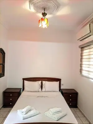 a bedroom with a bed with two white towels on it at Riad familiale à Marrakech in Marrakech