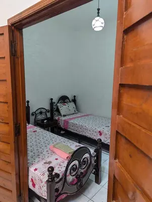 a bedroom with two beds and a mirror at Riad familiale à Marrakech in Marrakech