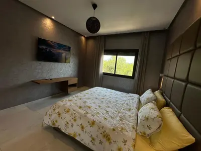 a bedroom with a bed and a desk and a window at Sweet Jacob's Appartment Gueliz City Center in Marrakech