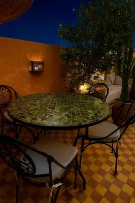 a green table and chairs on a patio at night at Vibrant Medina Loft and Roof Top in Marrakech