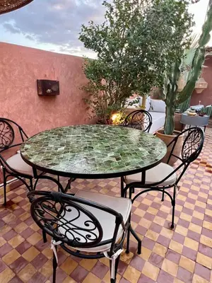 a glass table and chairs on a patio at Vibrant Medina Loft and Roof Top in Marrakech