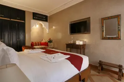 a hotel room with a bed and a television at Riad Omara al Kasbah in Marrakech