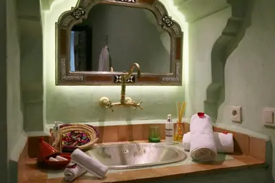 a bathroom with a sink and a mirror at Riad Omara al Kasbah in Marrakech
