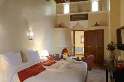 a bedroom with a bed and a fireplace in it at Riad Omara al Kasbah in Marrakech