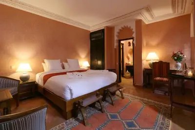 a bedroom with a bed and a table and a desk at Riad Omara al Kasbah in Marrakech