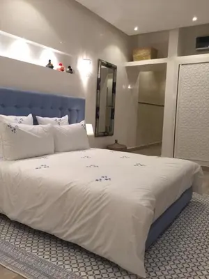 a bedroom with a large bed with a blue headboard at Riad Tsar Mimoun in Marrakech