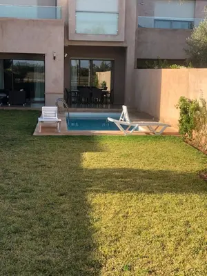 a house with a pool and two chairs in the yard at Villa prestige in Marrakech