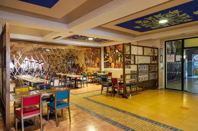 a restaurant with tables and chairs in a room at Rose Aqua Park Hotel in Marrakech