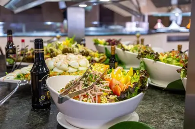 a buffet with bowls of food and bottles of wine at Rose Aqua Park Hotel in Marrakech