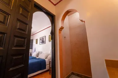 a room with a bed and a door with a mirror at Maison Ayda in Marrakech