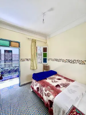 a bedroom with a bed and a window at Hotel Medina in Marrakech