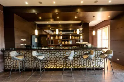 a kitchen with a bar with stools at Zephyr Targa Marrakech in Marrakech