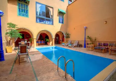 a swimming pool in a courtyard with a building at Riad la villa bleue & SPA in Marrakech