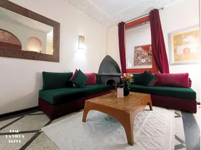 a living room with two green couches and a table at Riad la villa bleue & SPA in Marrakech
