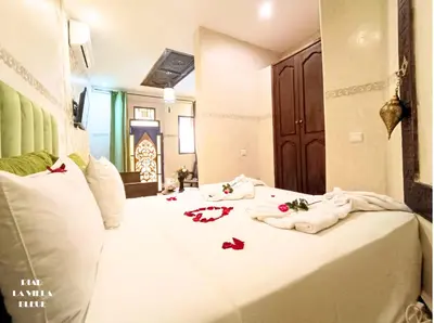 a white bed with towels and flowers on it at Riad la villa bleue & SPA in Marrakech