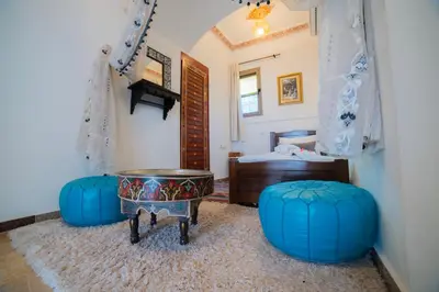 a room with two blue ottomans and a bedroom at Riad Arabic House & Spa in Marrakech