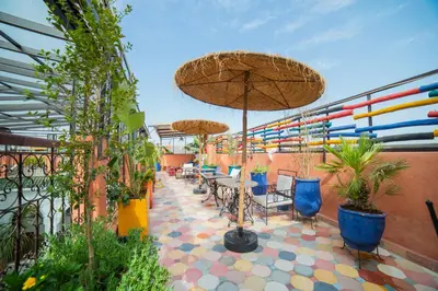 a patio with tables and chairs with umbrellas and plants at Riad Arabic House & Spa in Marrakech