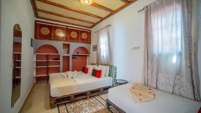 a bedroom with two beds and a large window at Riad Arabic House & Spa in Marrakech