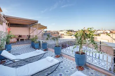 a balcony with chairs and potted plants on a building at Riad Azalia in Marrakech