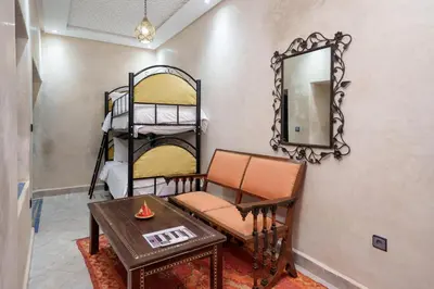 a room with a table and a mirror and bunk beds at Riad Azalia in Marrakech
