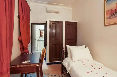 a bedroom with a bed and a desk and a mirror at Riad Azalia in Marrakech