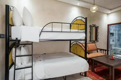 a room with two bunk beds and a table at Riad Azalia in Marrakech
