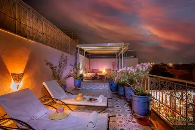 a balcony with chairs and plants on a building at Riad Azalia in Marrakech