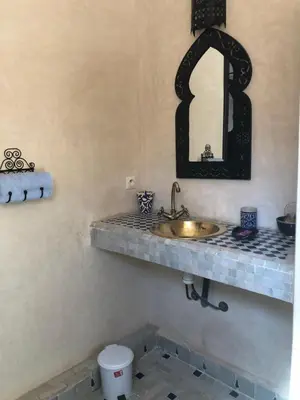 a bathroom with a sink and a mirror at Riad Côté palmeraie in Marrakech