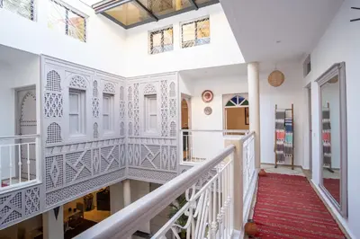 a staircase in a home with white railing and windows at Riad Bibazia in Marrakech