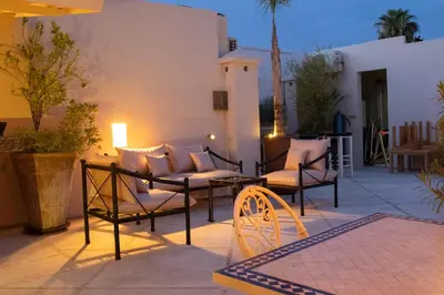 a patio with a couch and chairs on a patio at Riad Bibazia in Marrakech